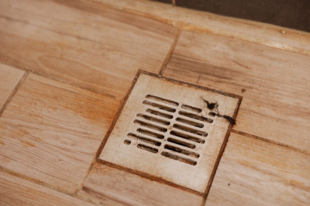 Dirty and disgusting shower drain, close up view. Clogged drain with rust stain, hair.
